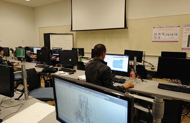 Two Master of Architecture students seated in the CAD Lab working on their architectural projects at the Spitzer School of Architecture in NYC.