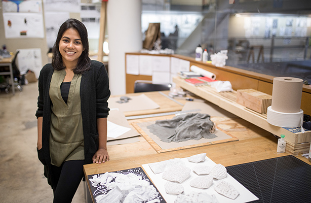 B Arch student standing next to architectural project at a studio classroom at the flagship public school of architecture in New York City.