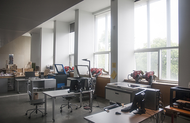 An interior view of the Digital Fabrication Shop at the premium Spitzer School of Architecture, featuring four large-bed laser cutters.