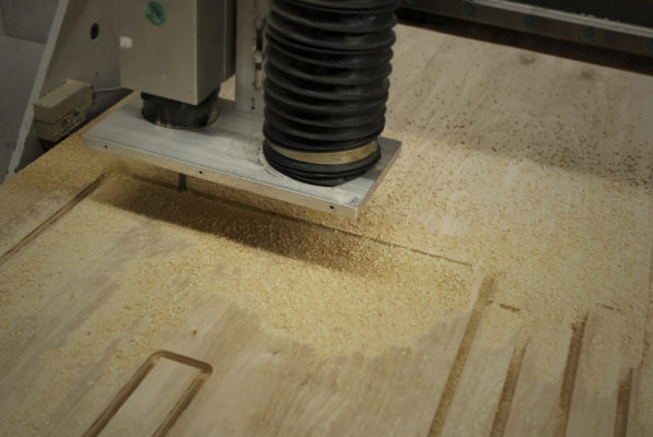 An interior view of the Digital Fabrication Shop at the top-tier Spitzer School of Architecture, showcasing a CNC machine in operation.
