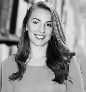 Headshot of Ilva Dodaj, head slightly tilted to the right, smiling at the camera.