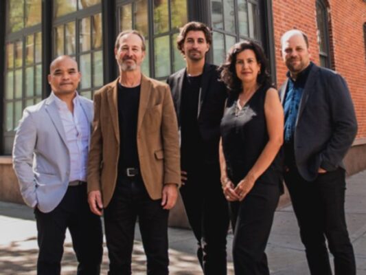 Five individuals stand, with Alex Nizhikhovskiy at the center.