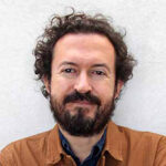 Headshot of Gabriel Diaz Montemayor, dressed in brown, smiling at the camera.