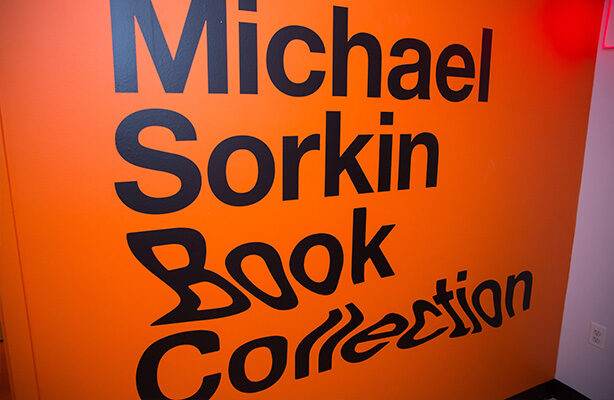 A vibrant orange wall with text indicating the presence of the Michael Sorkin Book Collection room behind it at the high-quality Spitzer School of Architecture.