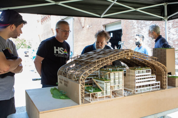 Two individuals admire the architectural model designed by Spitzer School of Architecture students.