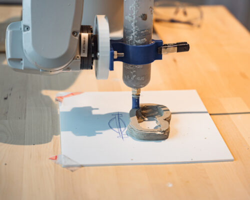 An interior view of the Robotics Lab at the best public architecture school in NYC, featuring an ABB robotic arm programmed to 3D print clay.