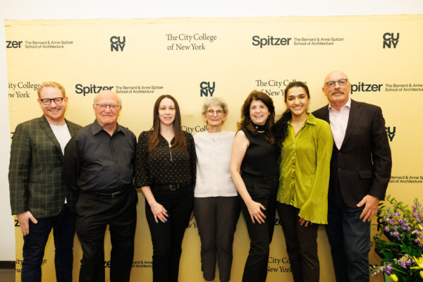 Seven individuals, including faculty and donors, smile and stand in front of a Spitzer School of Architecture backdrop.