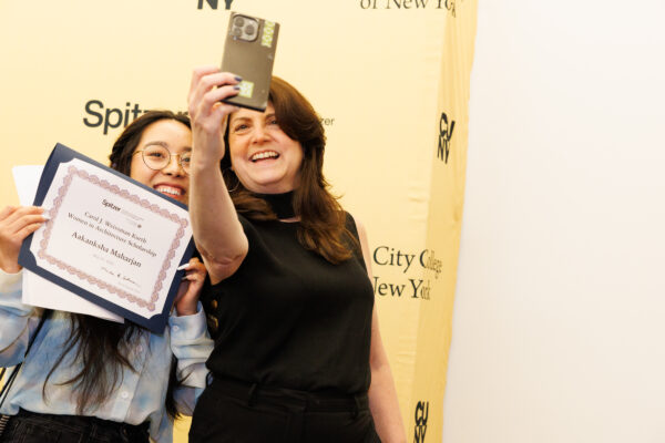 An awardee and donor take a selfie in front of a Spitzer School of Architecture backdrop.