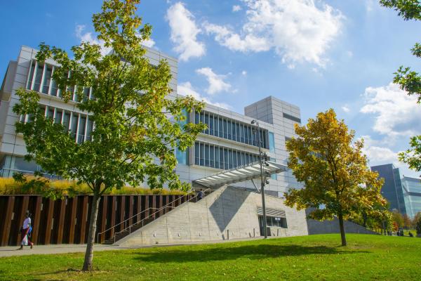 Photograph of the Spitzer School of Architecture with trees in the foreground and a clear blue sky.
