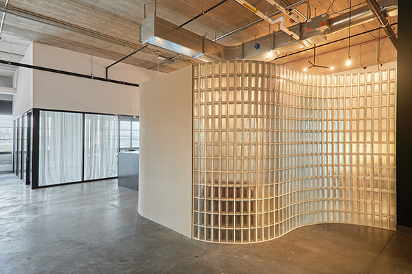 Image of glass blocked wall with overhead hanging lighting.