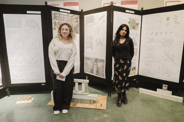 Two people standing in front of poster boards.